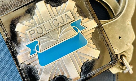 legitymacja policjanta. Obok kajdanki