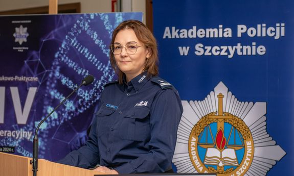 policjantka stoi na mównicy, w tle napis Akademia Policji w Szczytnie