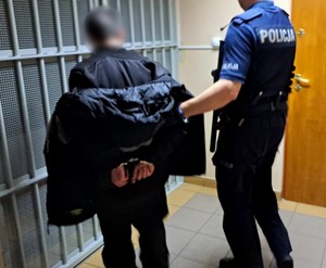 policjant prowadzi zatrzymanego