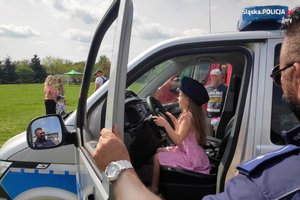 Na zdjęciu widać dziewczynkę siedzącą w policyjnym radiowozie