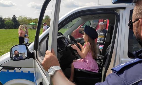 Na zdjęciu widać dziewczynkę siedzącą w policyjnym radiowozie