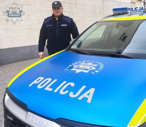 policjant stoi przy radiowozie