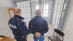 policjant prowadzi zatrzymanego