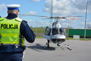 plecy policjanta, w tle śmigłowiec