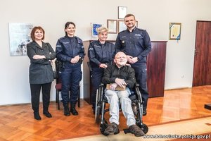 Wspólne zdjęcia Chłopak na wózku inwalidzkim z opiekunami i komendantem