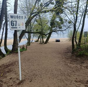 Tablica informująca o wejściu na plażę, w głębi widoczny pojazd, którego kierujący został ukarany