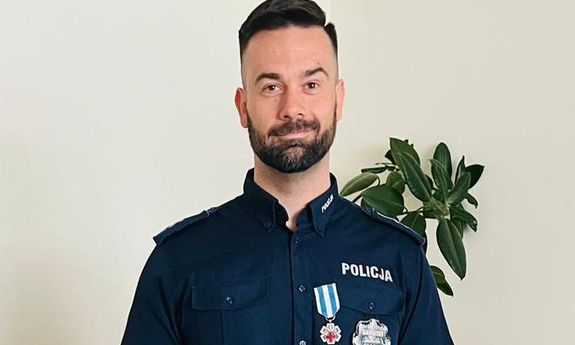 policjant trzyma list gratulacyjny