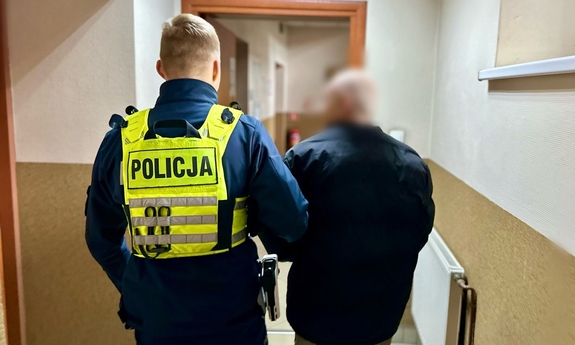 zatrzymany prowadzony przez korytarz przez policjanta