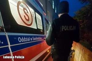policjant stoi przy karetce
