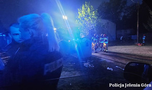 Policjanci i strażacy stojący przed domem