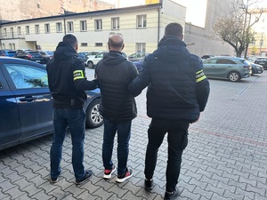 Policjanci prowadzą zatrzymanego