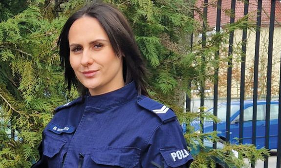 policjantka stoi na tle drzew