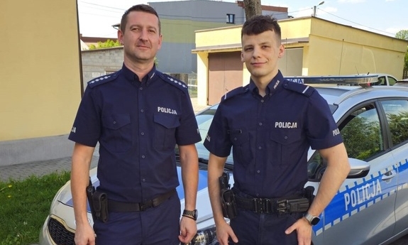 dwaj policjanci przy radiowozie