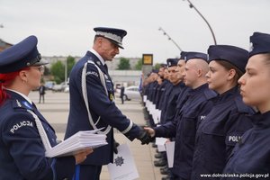 Nowi funkcjonariusze w trakcie uroczystości ślubowania. Komendant wojewódzki Policji we Wrocławiu gratuluje policjantom