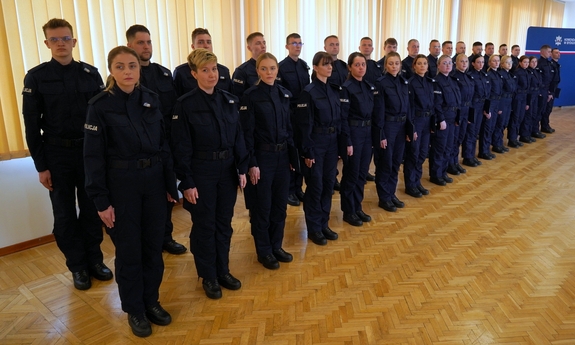 nowi policjanci i policjantki stoją w dwuszeregu podczas uroczystości