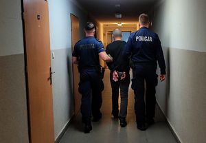 policjanci idą z zatrzymanym