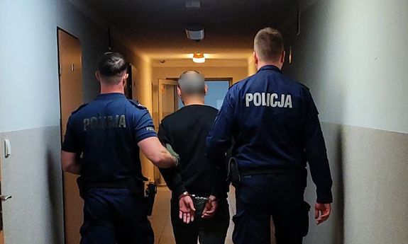 policjanci idą z zatrzymanym