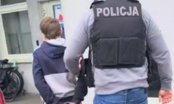 policjant prowadzi zatrzymanego