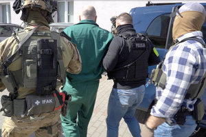 policjanci prowadzą zatrzymanego