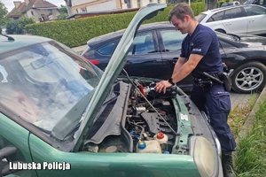policjant pomaga odpalić samochód