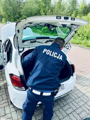 policjant przeszukuje pojazd zatrzymanego mężczyzny