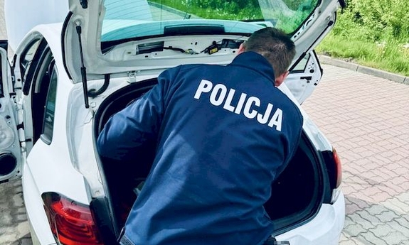 policjant przeszukuje pojazd zatrzymanego mężczyzny