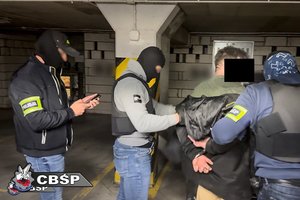 policjanci idą z zatrzymanym