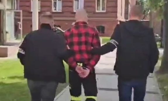policjanci prowadzą zatrzymanego