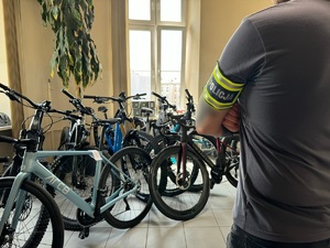 policjant stoi przodem do rowerów