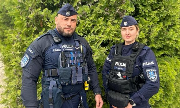 policjanci stoją na tle zieleni