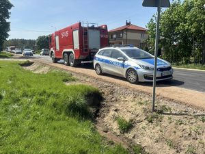 Droga, na której stoi wóz gaśniczy straży pożarnej i policyjny radiowóz