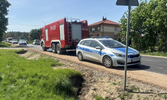 Droga na której stoi wóz gaśniczy straży pożarnej i policyjny radiowóz