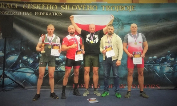 Zdjęcie grupowe, na którym widzimy zawodników reprezentujących Policję w zawodach z medalami na szyi, w dłoniach trzymają dyplomy, jeden z zawodników trzyma puchar