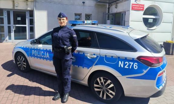 umundurowana policjantka stoi przy radiowozie