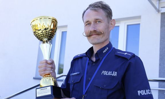 policjant stoi z pucharem