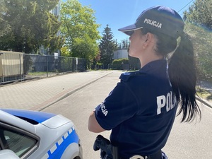 na zdjęciu umundurowana policjantka stoi przy radiowozie