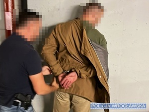 policjant zakłada kajdanki zatrzymanemu
