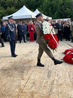 komendant główny policji składa wieniec kwiatów