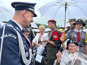 komendant główny Policji rozmawia z kombatantem, obok stoją harcerze