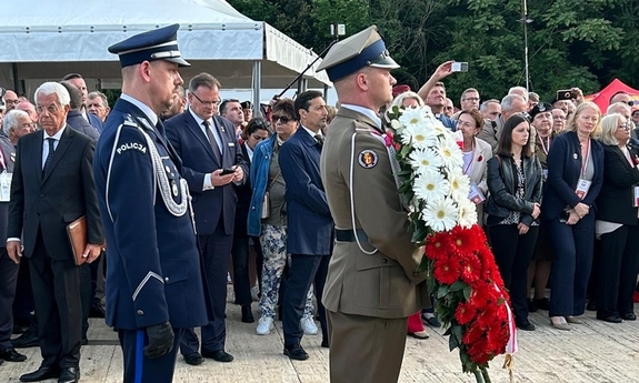 komendant główny policji składa wieniec kwiatów
