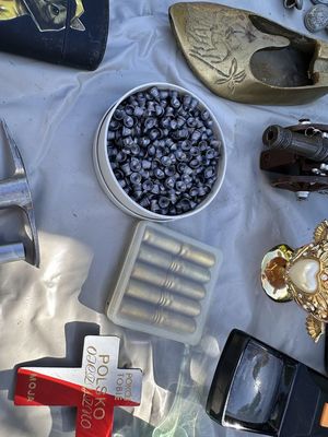 amunicja w plastikowym opakowaniu i różne rzeczy porozkładane na białym materiale
