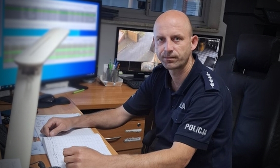 policjant siedzi przy biurku