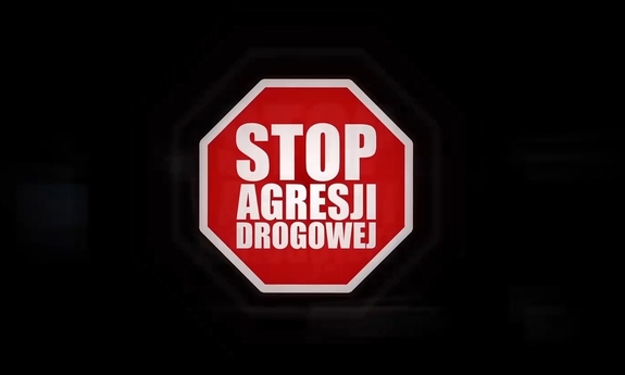 grafika przedstawia na czarnym tle znak ostrzegawczy z napisem stop agresji drogowej