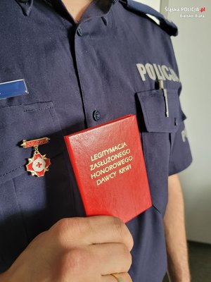 trzymana w dłoni legitymacja zasłużonego honorowego dawcy krwi