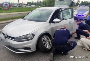 policjanci pomagają kobiecie wymienić koło