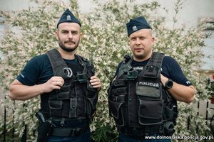 policjanci stoją na tle krzaków