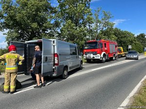 nieoznakowany radiowóz, za nim wóz strażacki