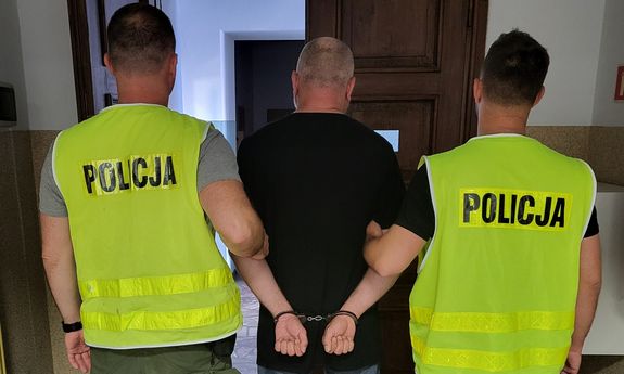 policjanci prowadzą zatrzymanego
