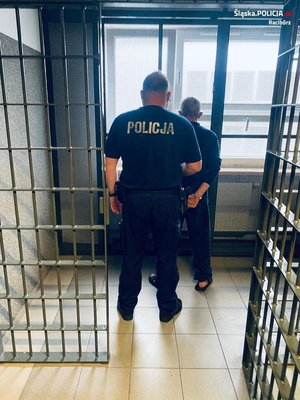 policjant wchodzi do celi z zatrzymanym