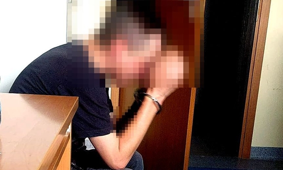 zatrzymany mężczyzna zakuty w kajdanki siedzi na krześle